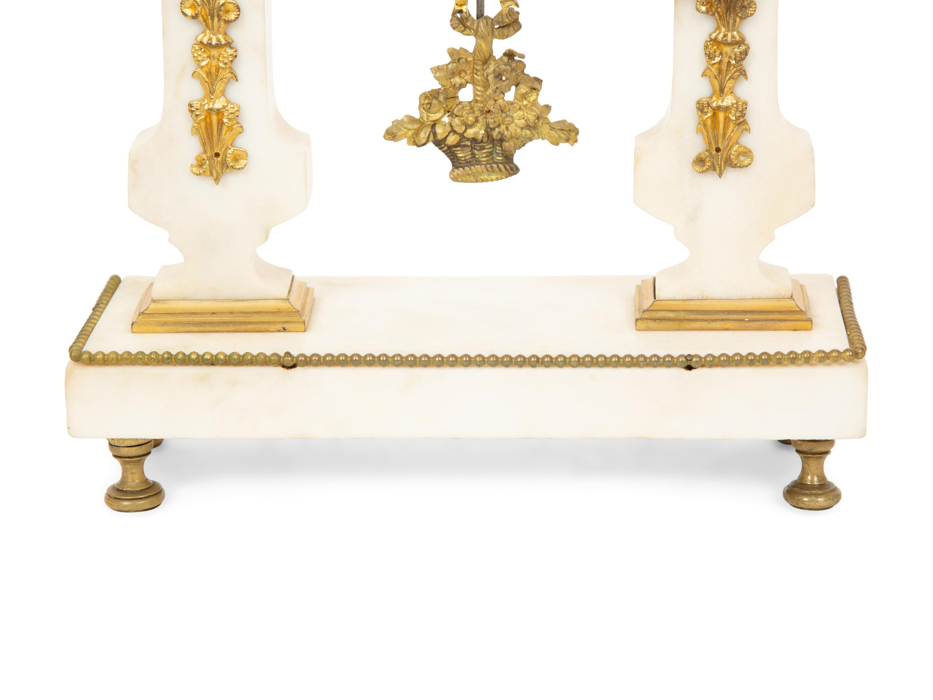 A French Gilt Bronze and Marble Mantel Clock with an Associated Pair of Urns