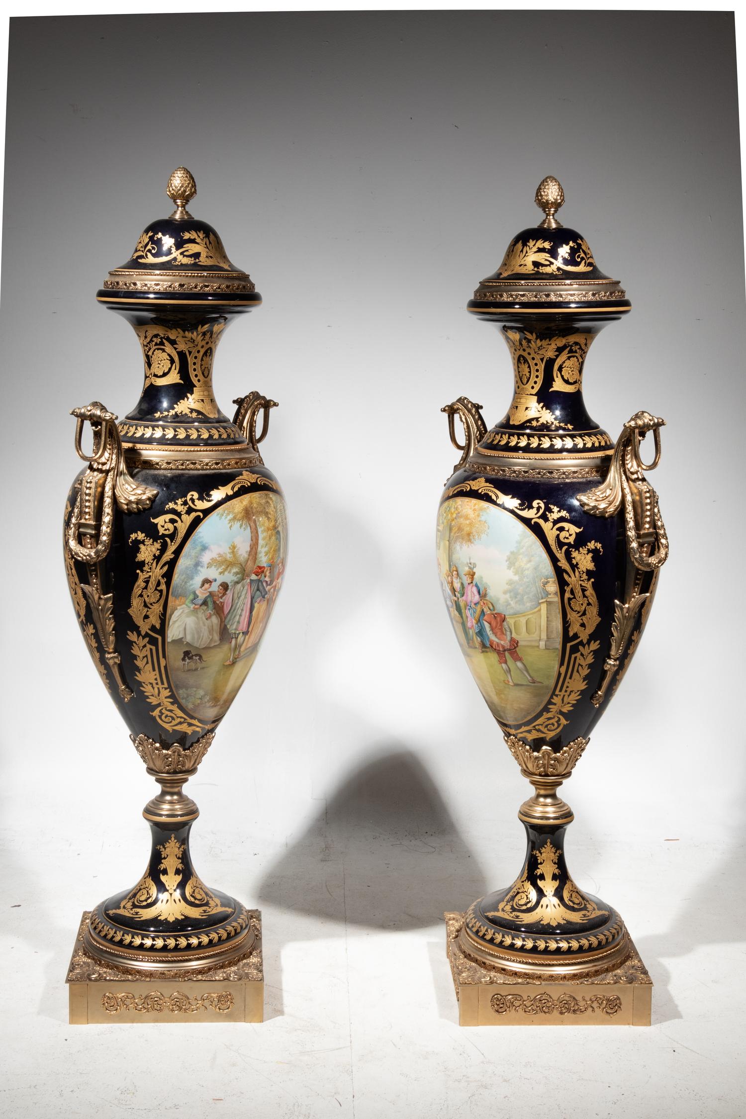 A Pair of Monumental Sèvres Style Gilt Metal Mounted Porcelain Covered Urns on Pedestals