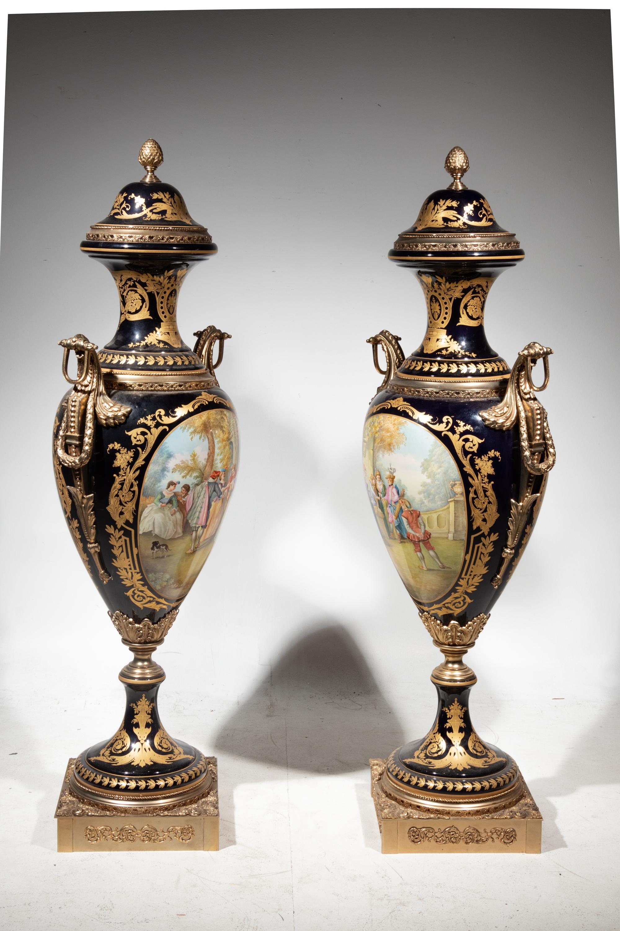A Pair of Monumental Sèvres Style Gilt Metal Mounted Porcelain Covered Urns on Pedestals