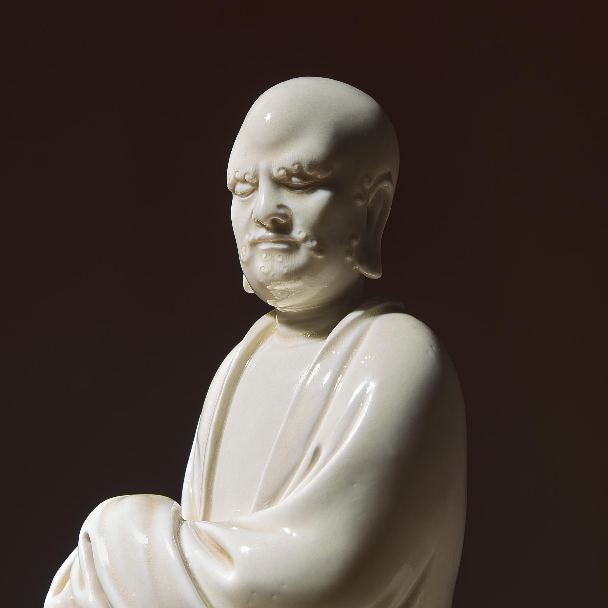 A Chinese Blanc-de-Chine Porcelain Seated Figure of Damo with 'He Chaozong' Mark, Qing Dynasty — 清 何朝宗款“隻履西歸”德化白瓷達摩坐像