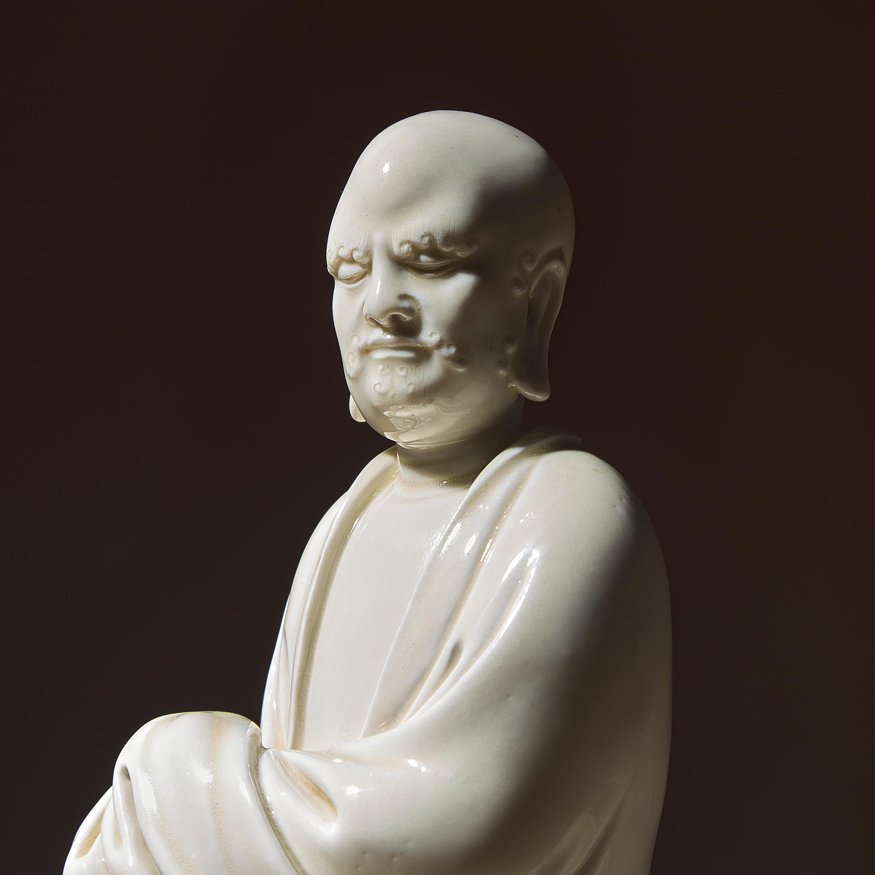 A Chinese Blanc-de-Chine Porcelain Seated Figure of Damo with 'He Chaozong' Mark, Qing Dynasty — 清 何朝宗款“隻履西歸”德化白瓷達摩坐像