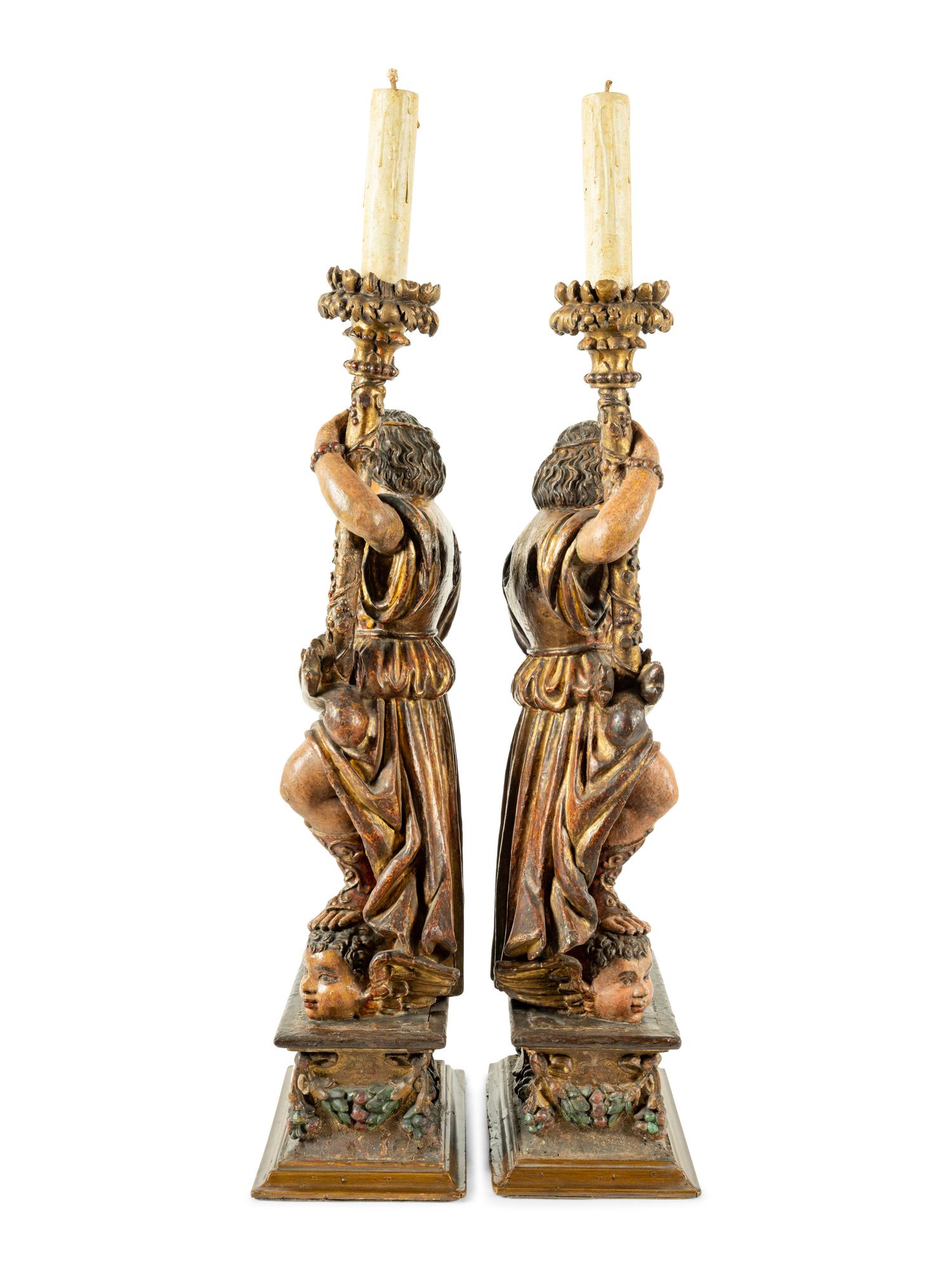 A Pair of Continental Carved, Painted and Parcel Gilt Figural Pricket Sticks