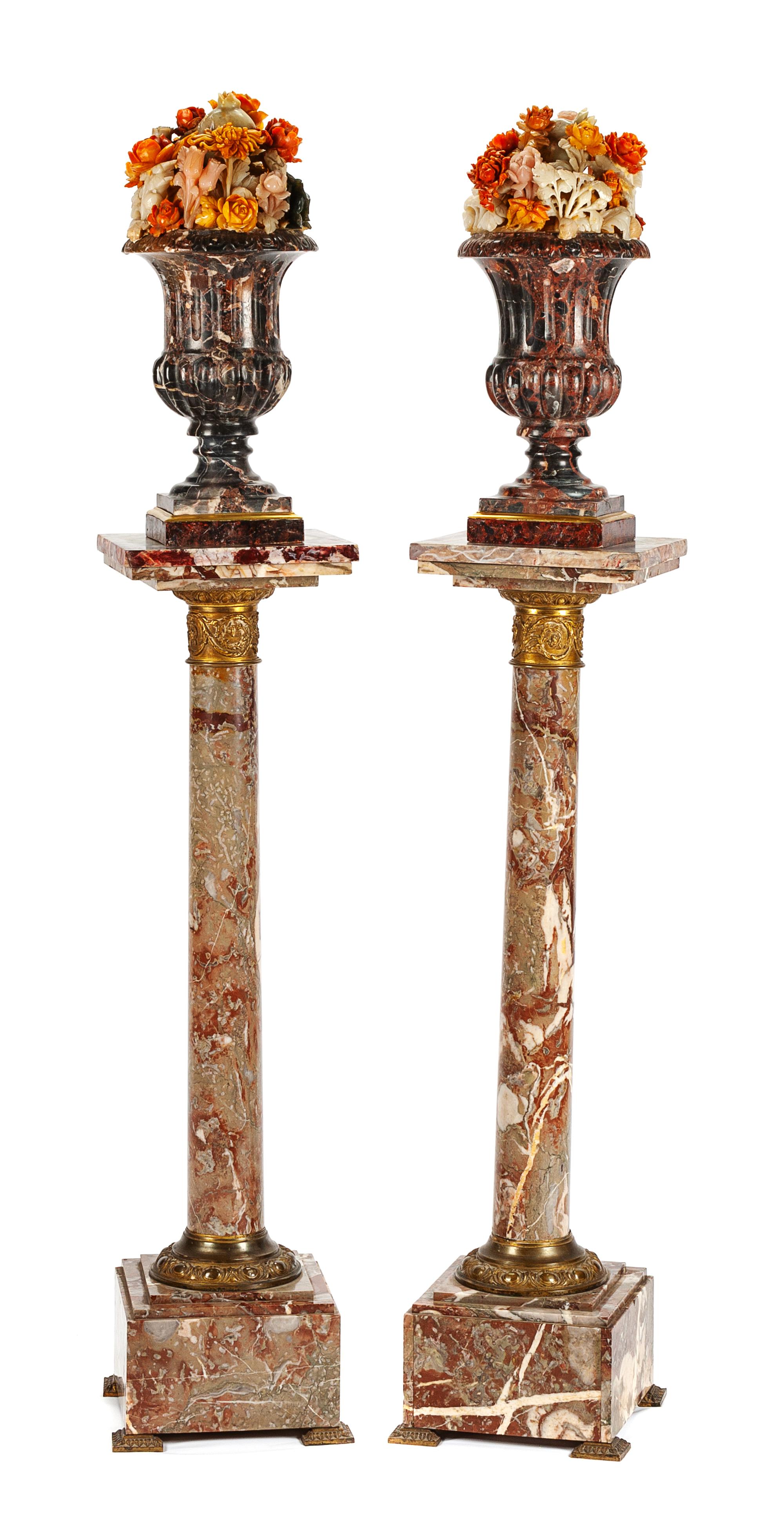 A Pair of Italian Carved Marble Urns with Floral Arrangements Height overall 21 1/2 inches.