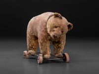 A Stuffed Bear Pull Toy with Rotating Head and Glass Eyes