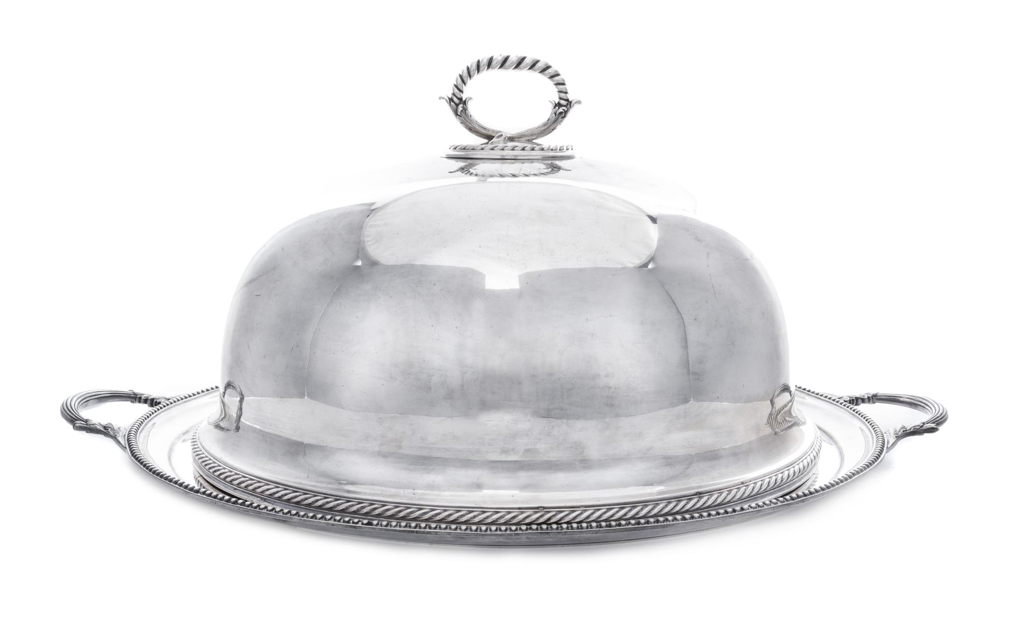An English Silver-Plate Cloche and Tray, Elkington Silver Co., Birmingham, each of oval form, the handled tray centered with a crest fe