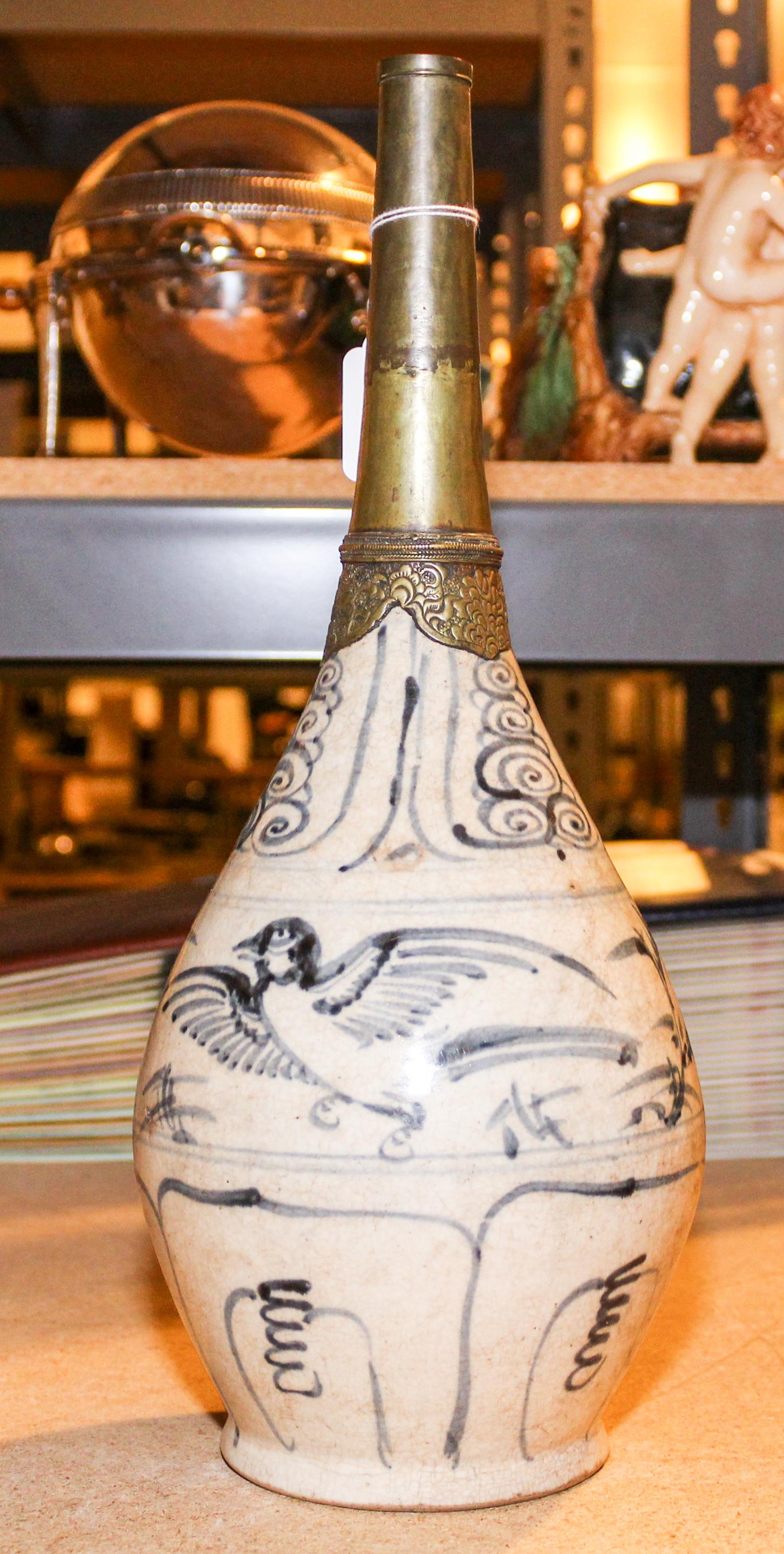 A Vietnamese Ceramic and Bronze Vessel, , having a bronze tapering spout surmounting a ceramic body with white ground and painted blue