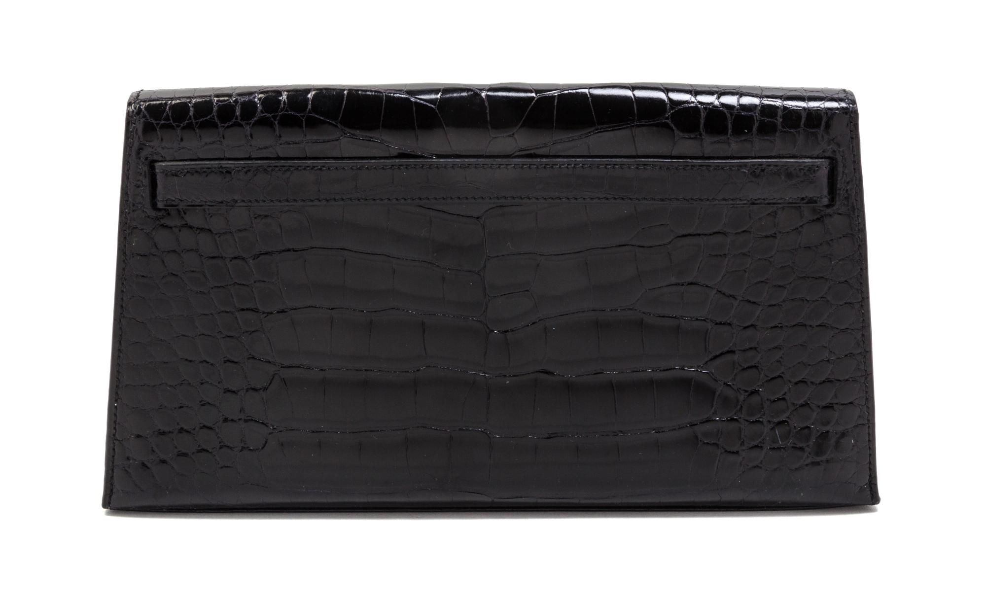 An Hermes Black Shiny Alligator Kelly Clutch Bag, 11 x 6 x 1 1/2 inches.