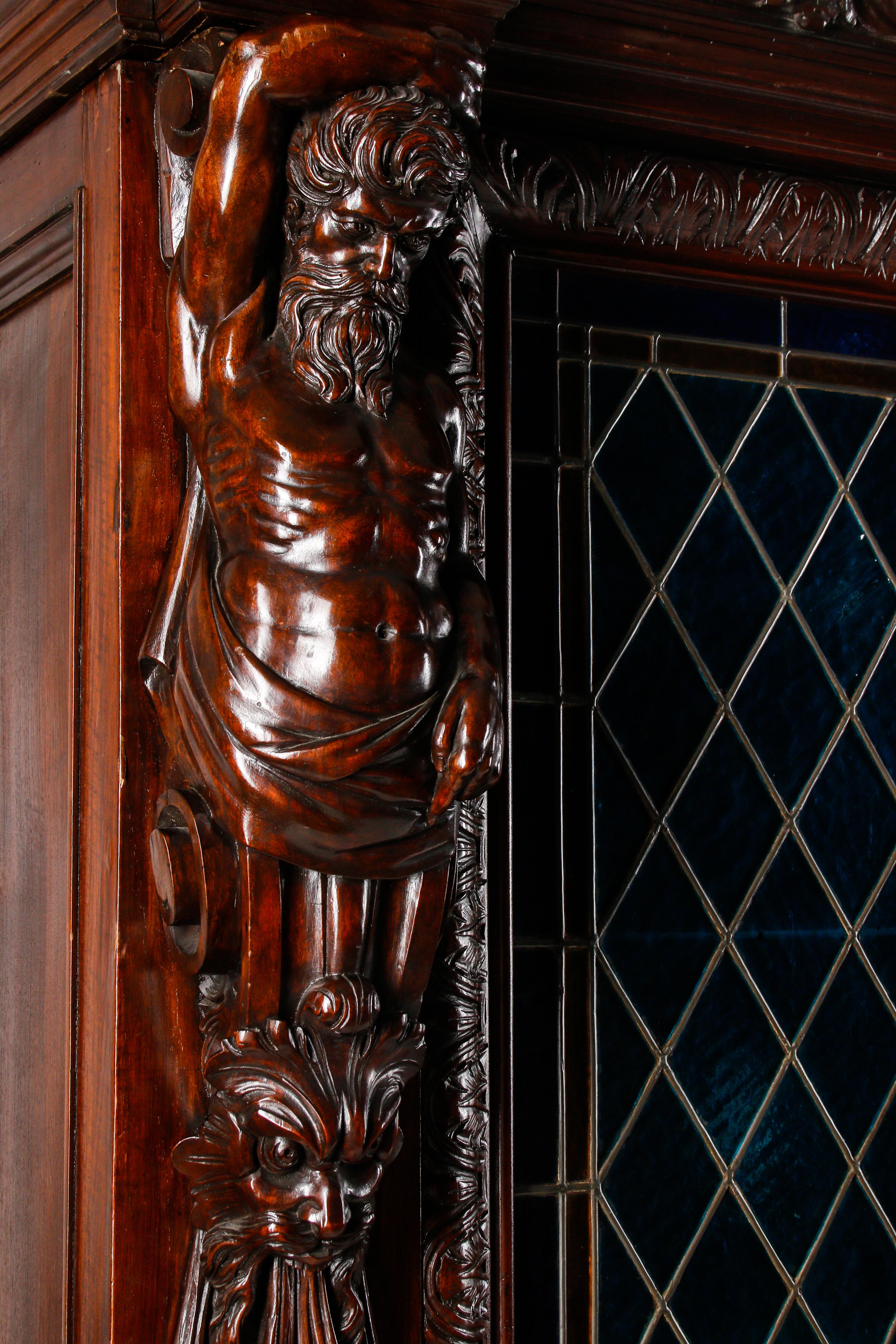 A Continental Renaissance Revival Carved Walnut and Leaded Glass Cabinet