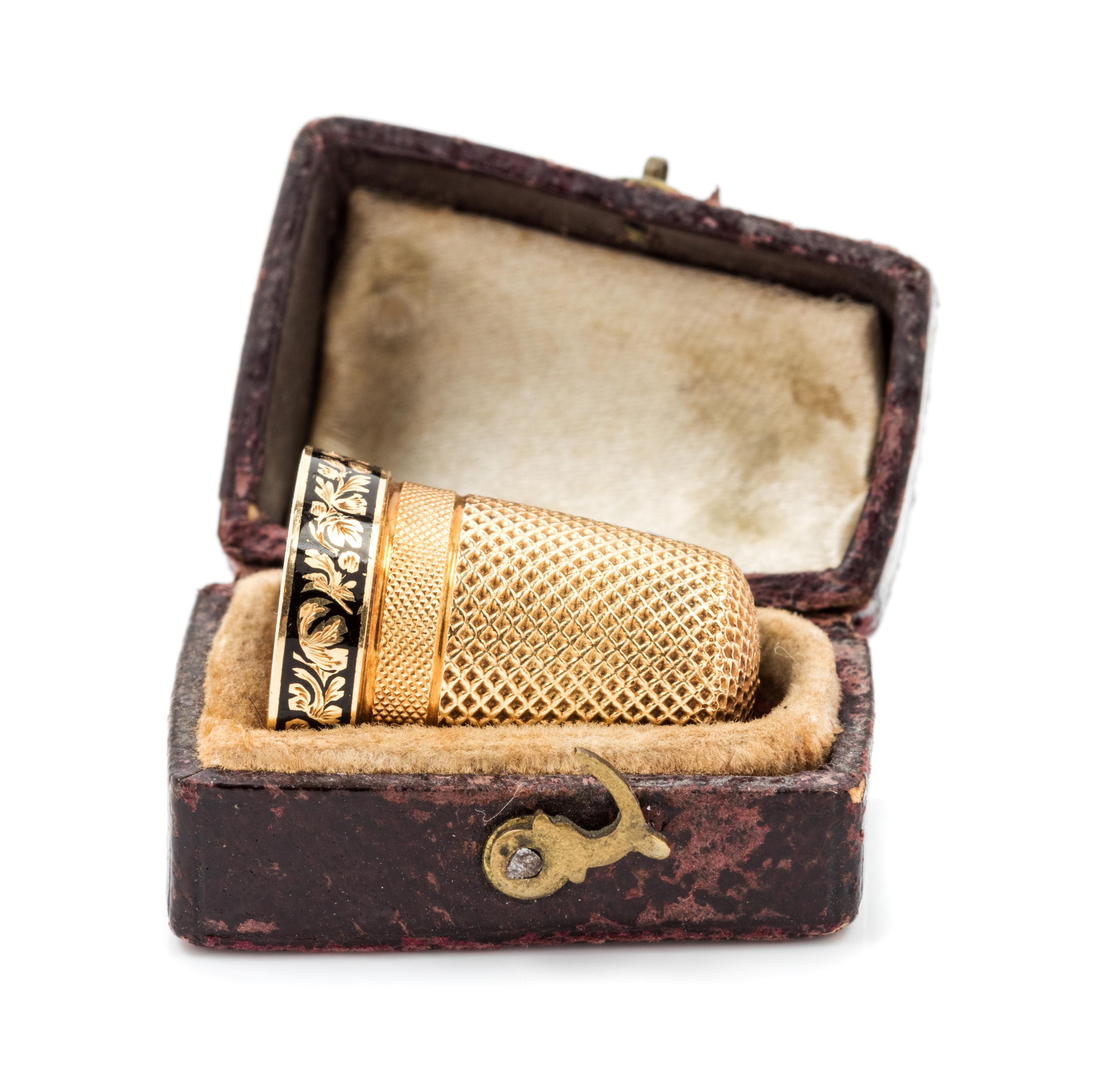 An American Yellow Gold and Enamel Thimble, , the knurled top and body above an engine turned band with an engraved cartouche and a flo
