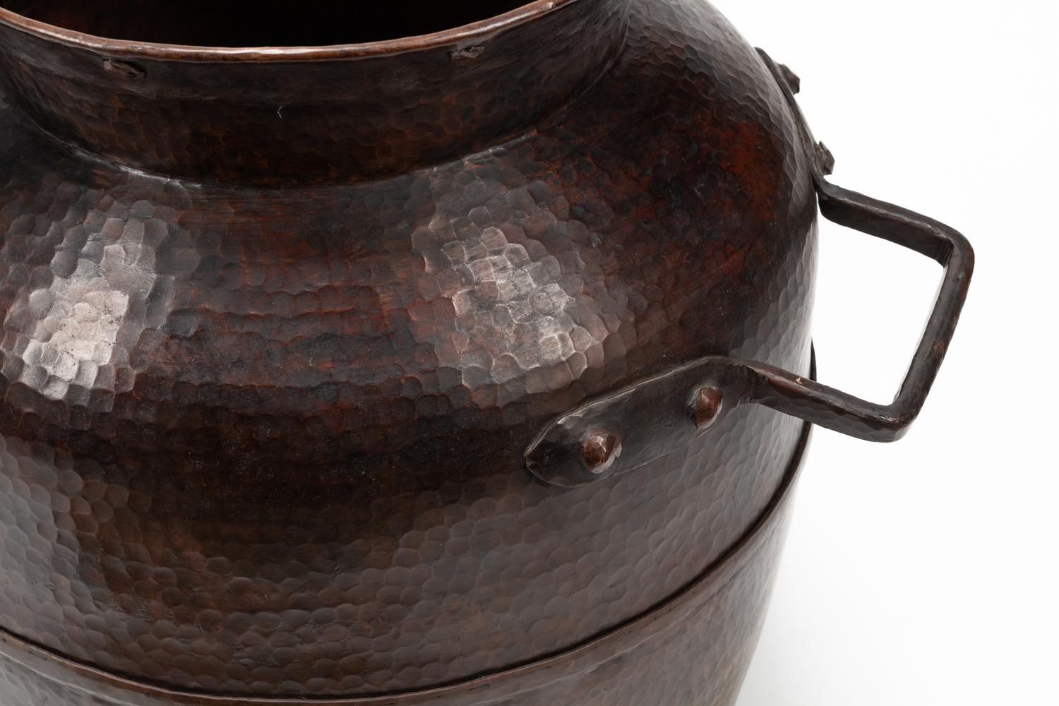 A Pair of Large Iron Mounted Hammered Metal Jars