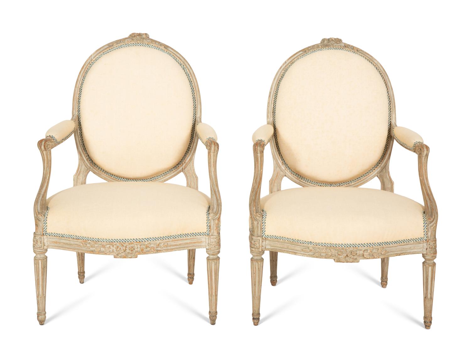 A Set of Four Louis XVI Grey-Painted and Parcel Gilt Fauteuils