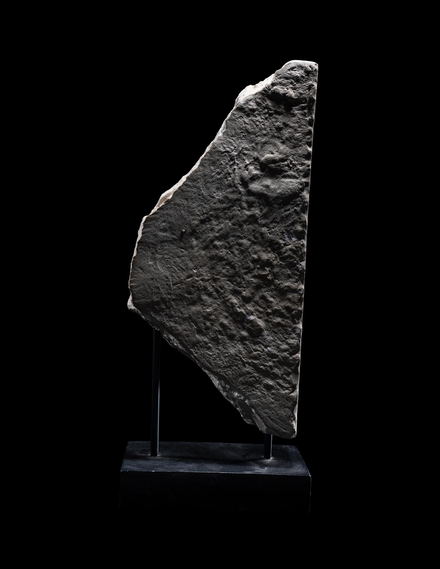 An Egyptian Limestone Stele Fragment with a Seated Pharaoh