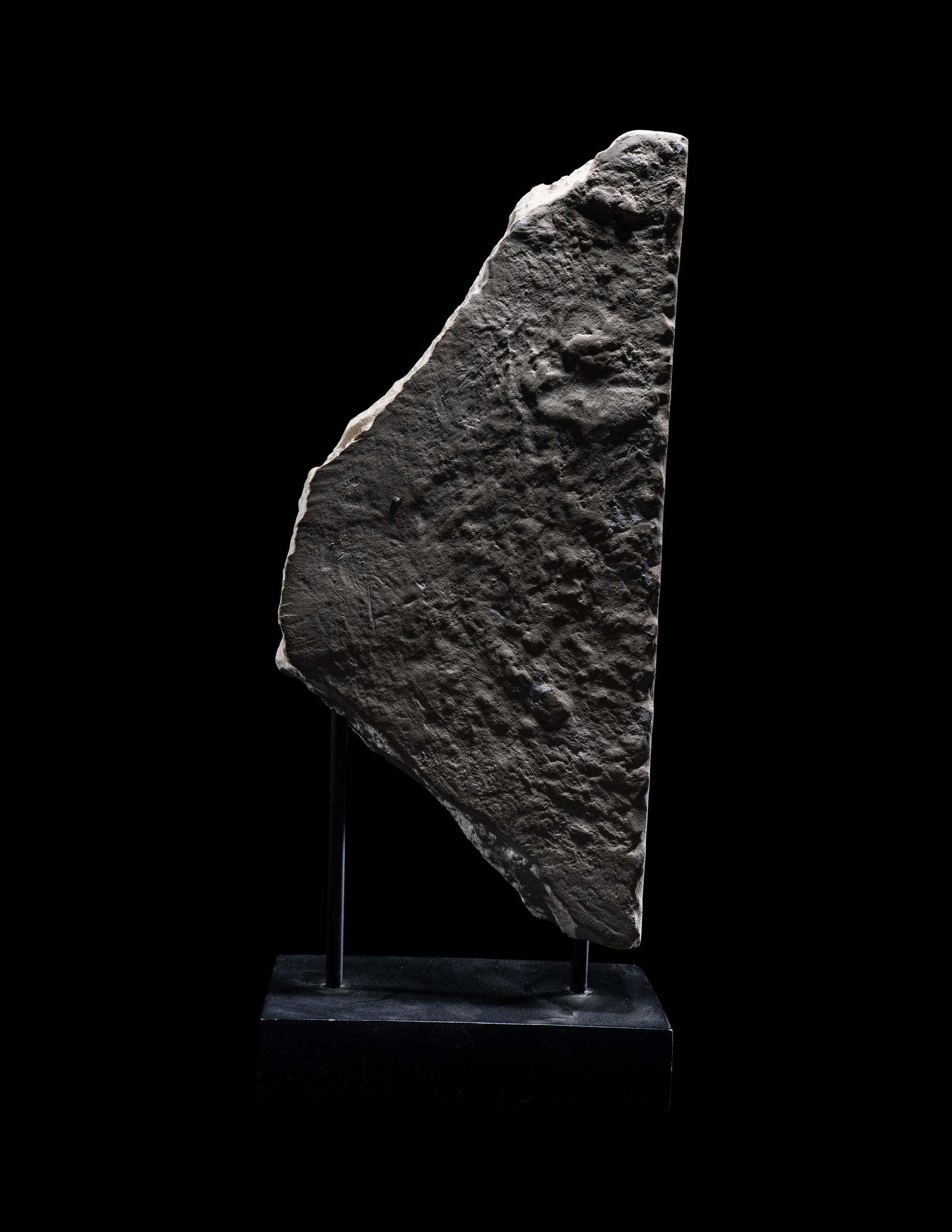 An Egyptian Limestone Stele Fragment with a Seated Pharaoh