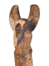 A Yaka Post, with forked finial painted blue and white, a mask in relief at the center