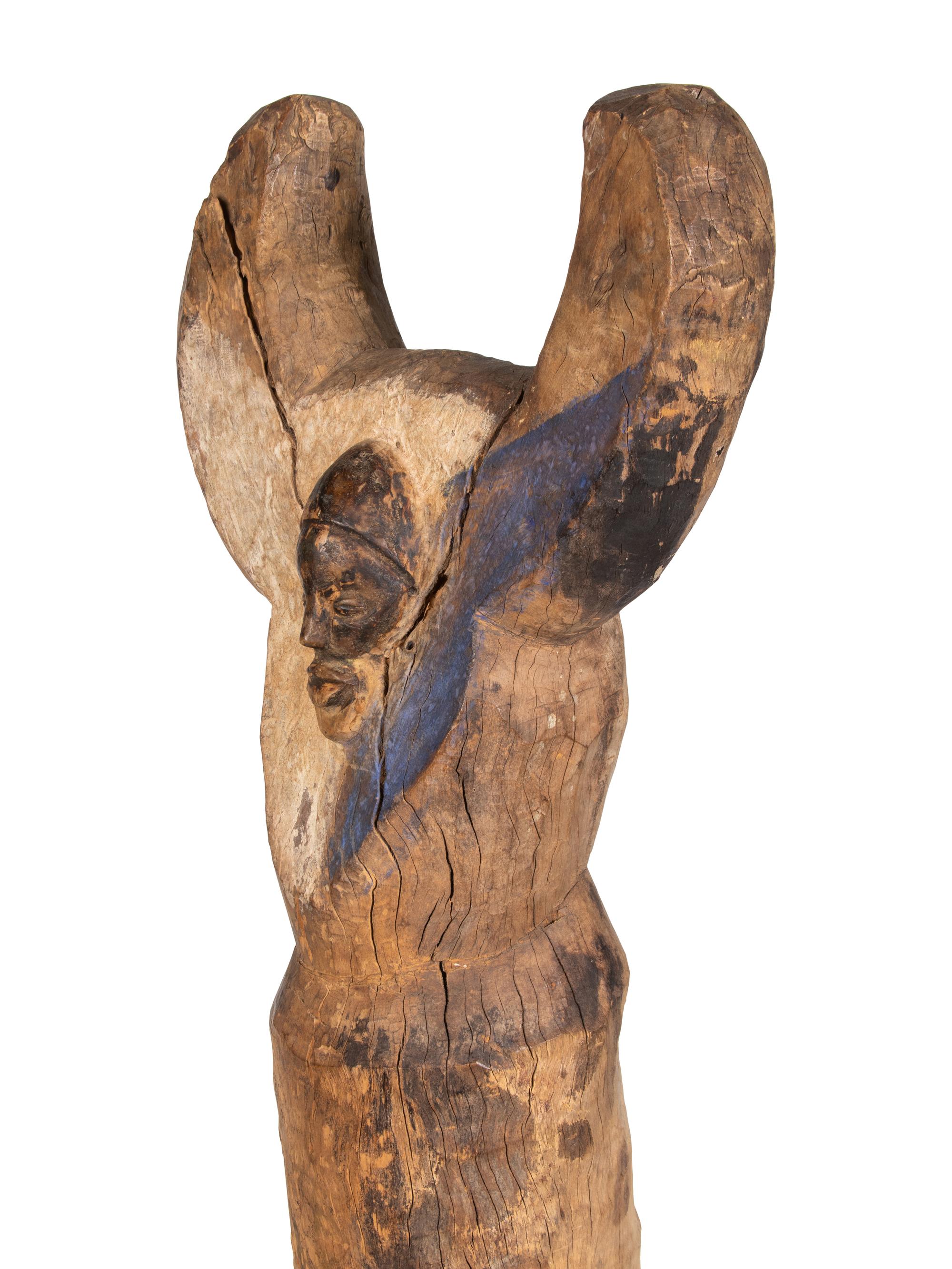 A Yaka Post, with forked finial painted blue and white, a mask in relief at the center