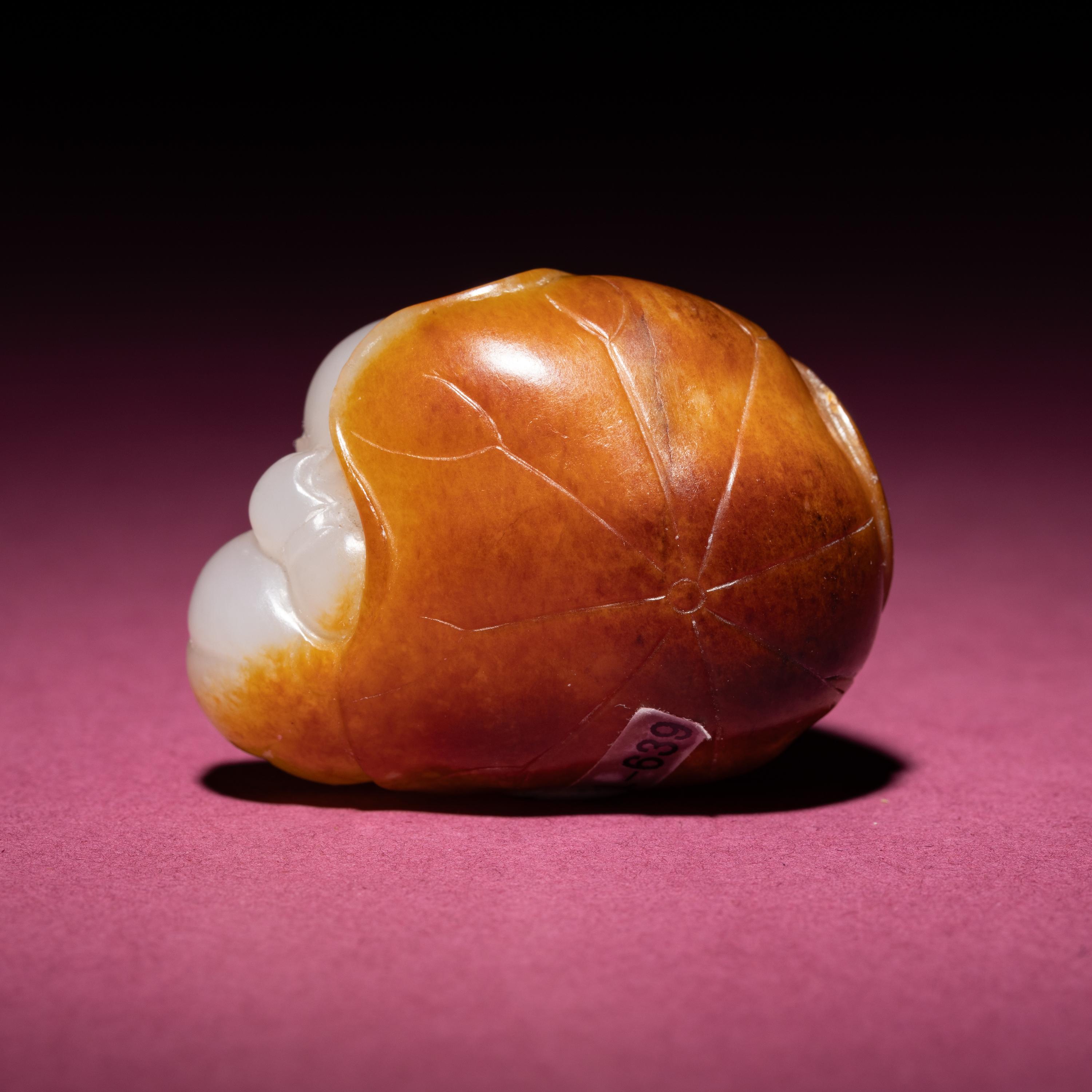 A Chinese Russet and White Jade Carving of a Boy with Lotus Pad, 18th/19th Century — 清中期 白玉留皮童子持荷把件