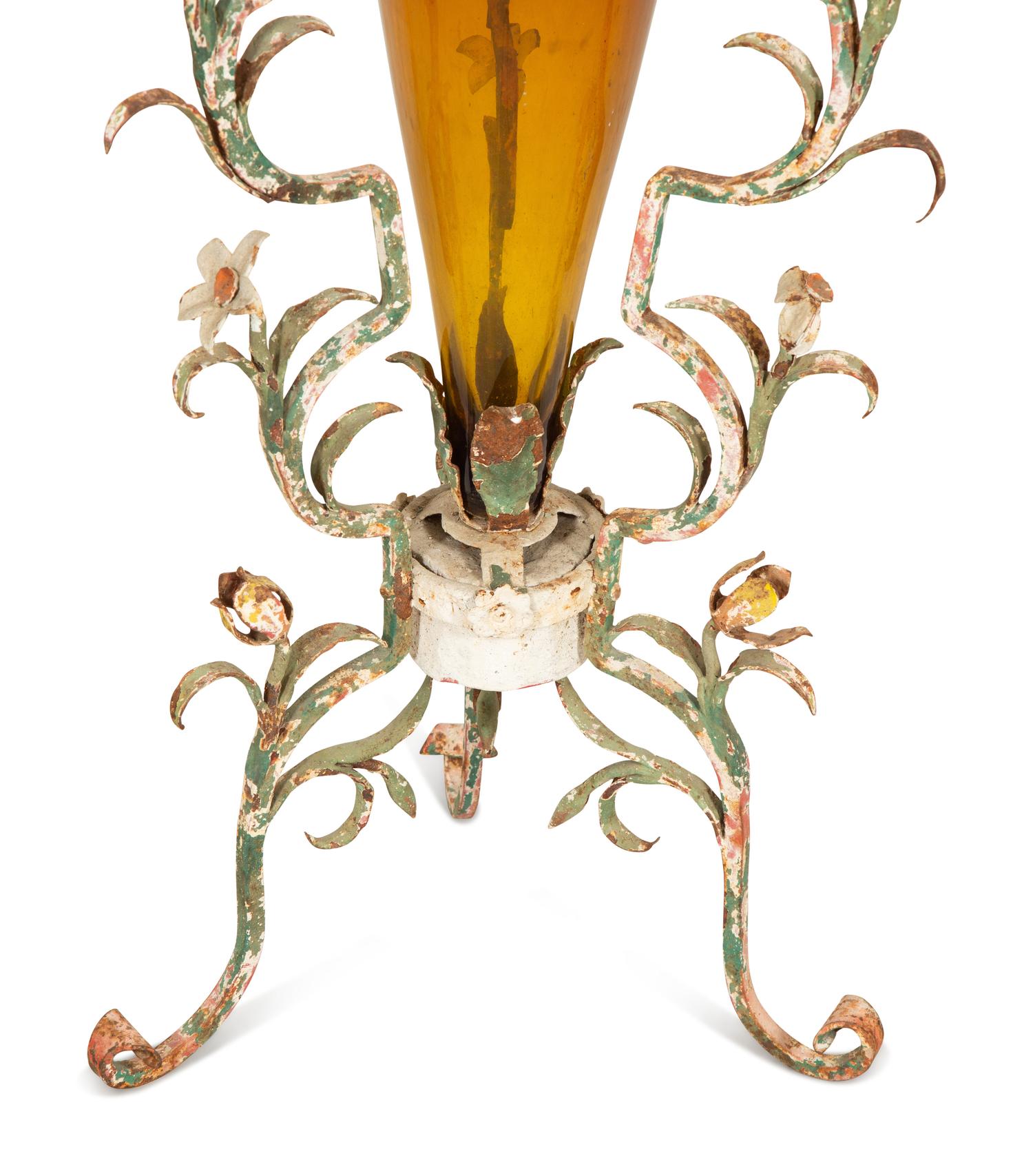 A Pair of Polychrome Painted Metal Stands with Amber Glass Amphora Vases
