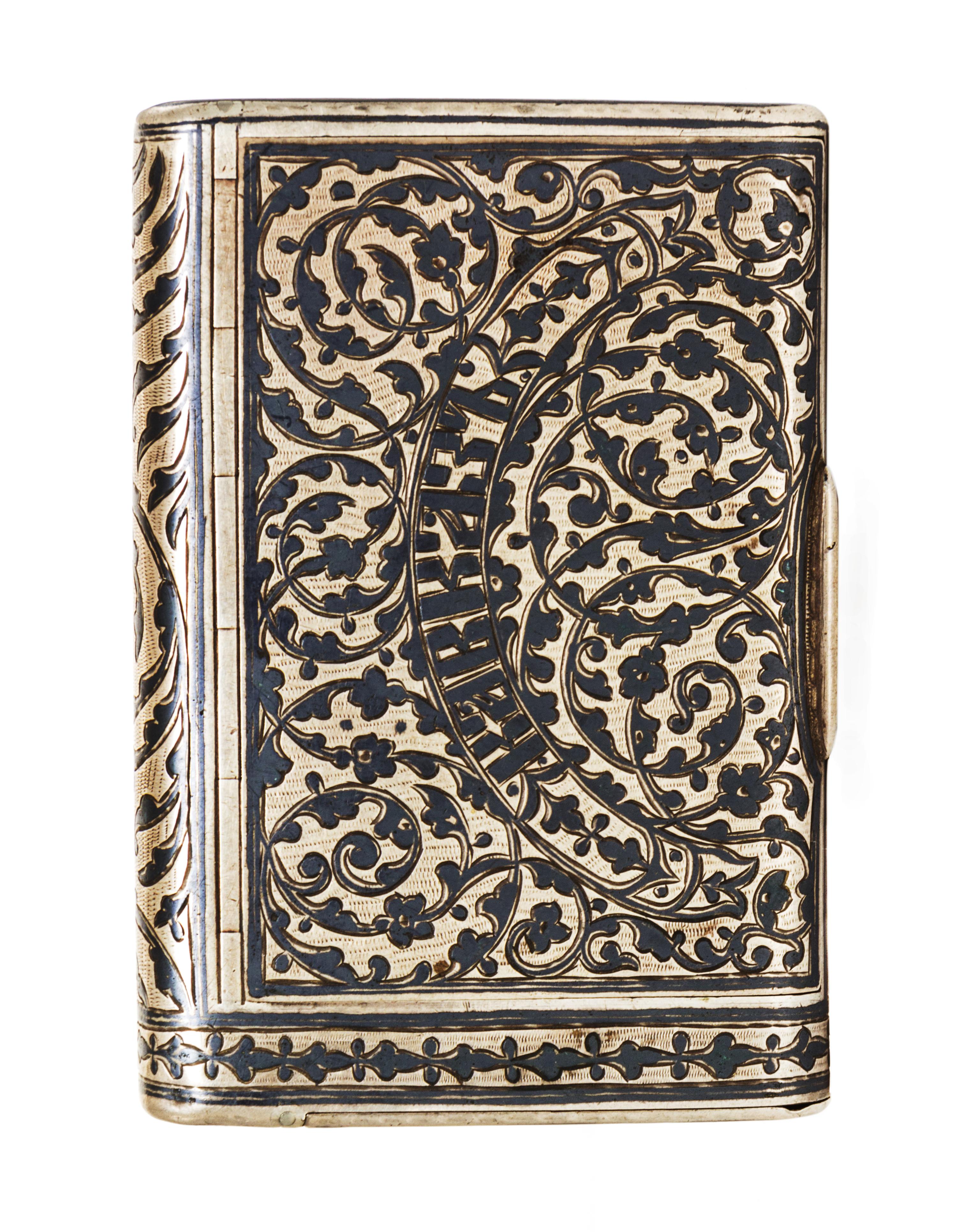 A Russian Niello Silver Cigarette Case, Moicye or Maxim Ivanov, 1896-1908, of rectangular form, the lid centered with Cyrillic script o