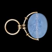 A Greek Blue Chalcedony Intaglio with a Satyr Holding a Herm — Set in a gold pendant