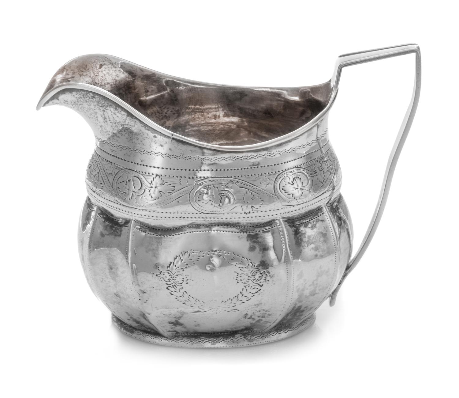 An Irish George III Silver Creamer, Robert Breading, Dublin, 1805, the bright-cut volute decorated collar above the lobed paneled body