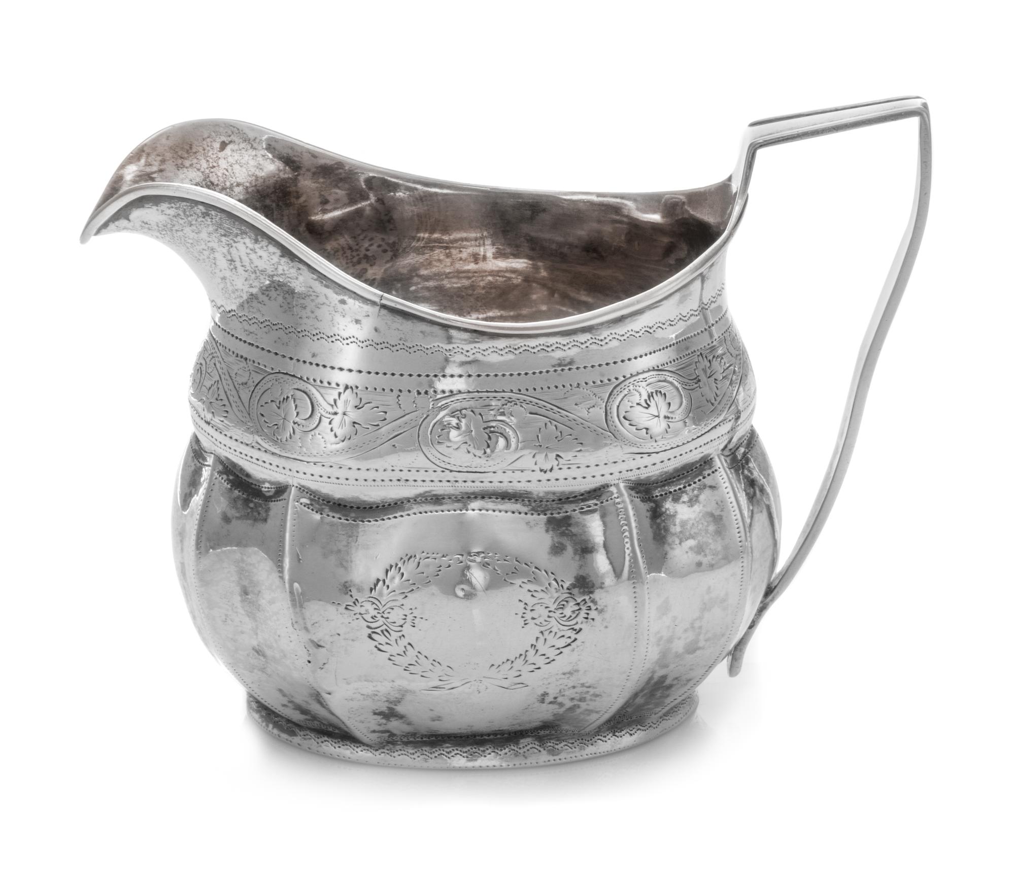 An Irish George III Silver Creamer, Robert Breading, Dublin, 1805, the bright-cut volute decorated collar above the lobed paneled body