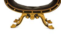 A Regency Ebonized and Parcel Gilt Curule Form Bench