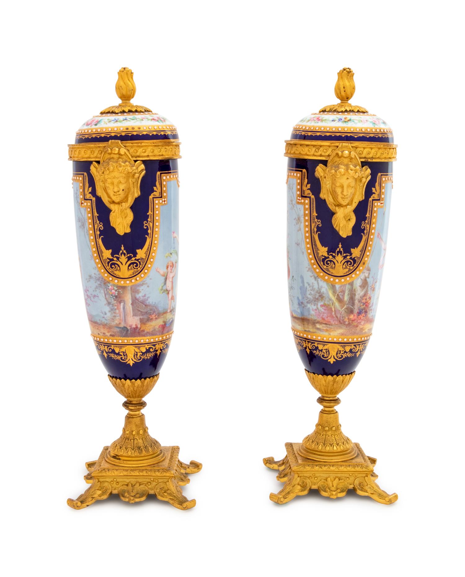 A Pair of Sèvres Style Gilt Bronze Mounted Painted, Parcel Gilt and "Jeweled" Porcelain Urns