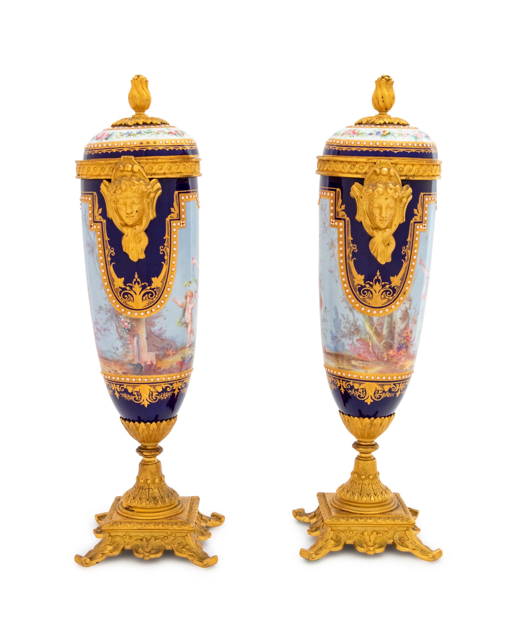 A Pair of Sèvres Style Gilt Bronze Mounted Painted, Parcel Gilt and "Jeweled" Porcelain Urns