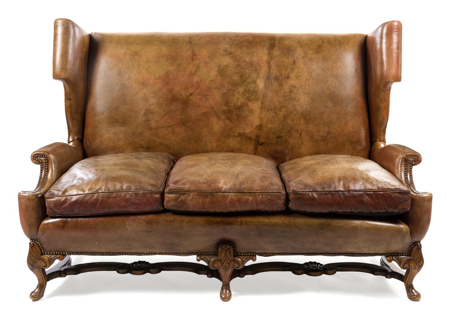 An English Leather Wingback Sofa Height 49 x width 70 x depth 37 1/2 inches. — LATE 19TH/EARLY 20TH CENTURY