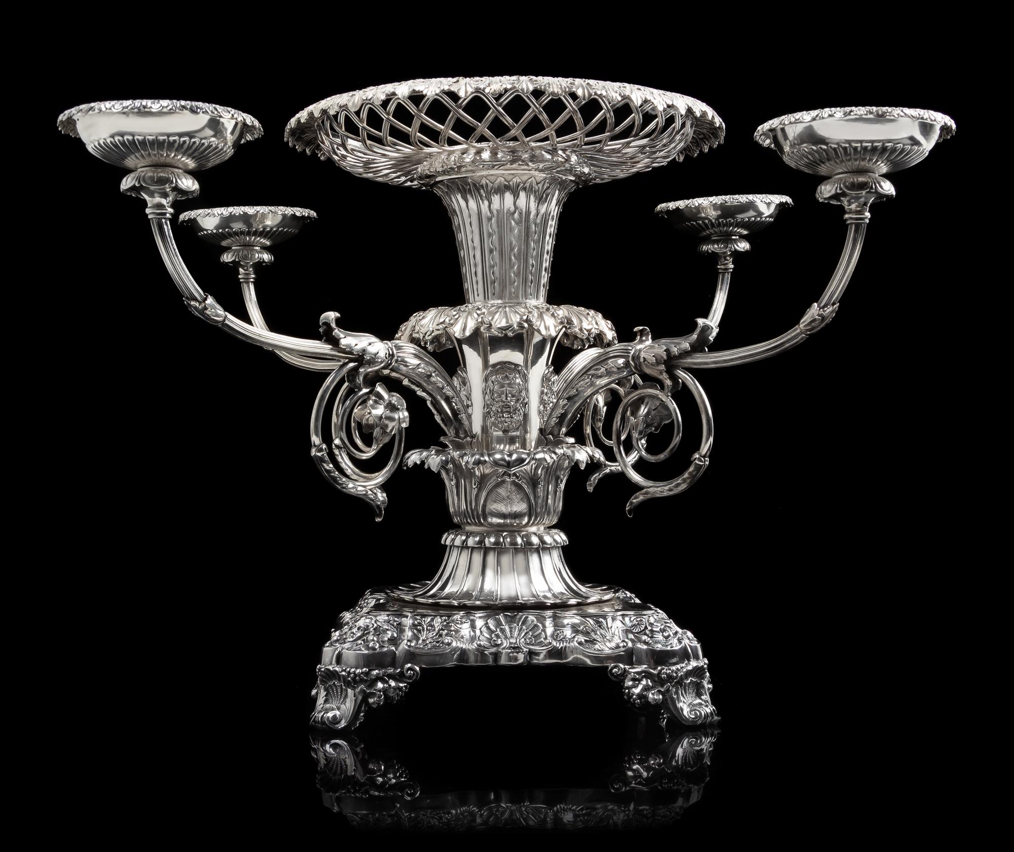 A George III Silver Epergne, Paul Storr, London, 1814, the foliate rim above an openwork basket and acanthus and mask decorated stem is