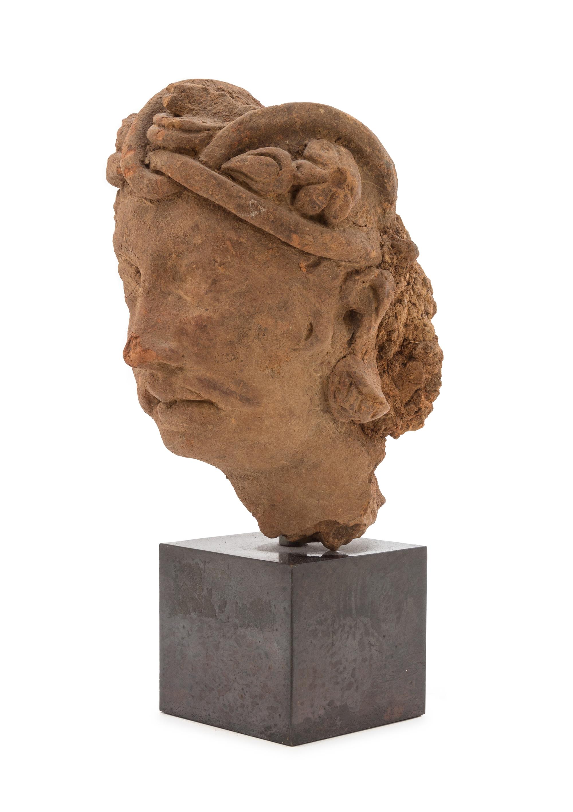 A Gandharan Terra Cotta Head of a Bodhisattva Height of head 8 inches. — HADDA REGION, 2ND CENTURY C.E.