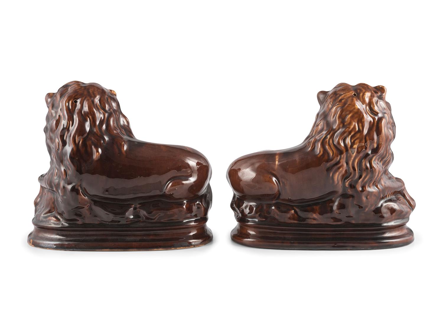 A Pair of Recumbent Lion Figures in Rockingham Glaze