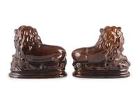 A Pair of Recumbent Lion Figures in Rockingham Glaze