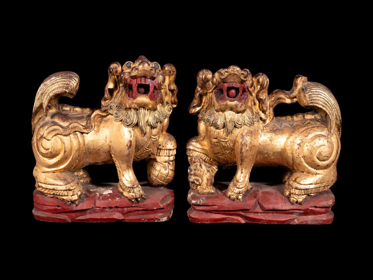 A Pair of Chinese Gilt and Red Lacquered Wood Figures of Fu Lions