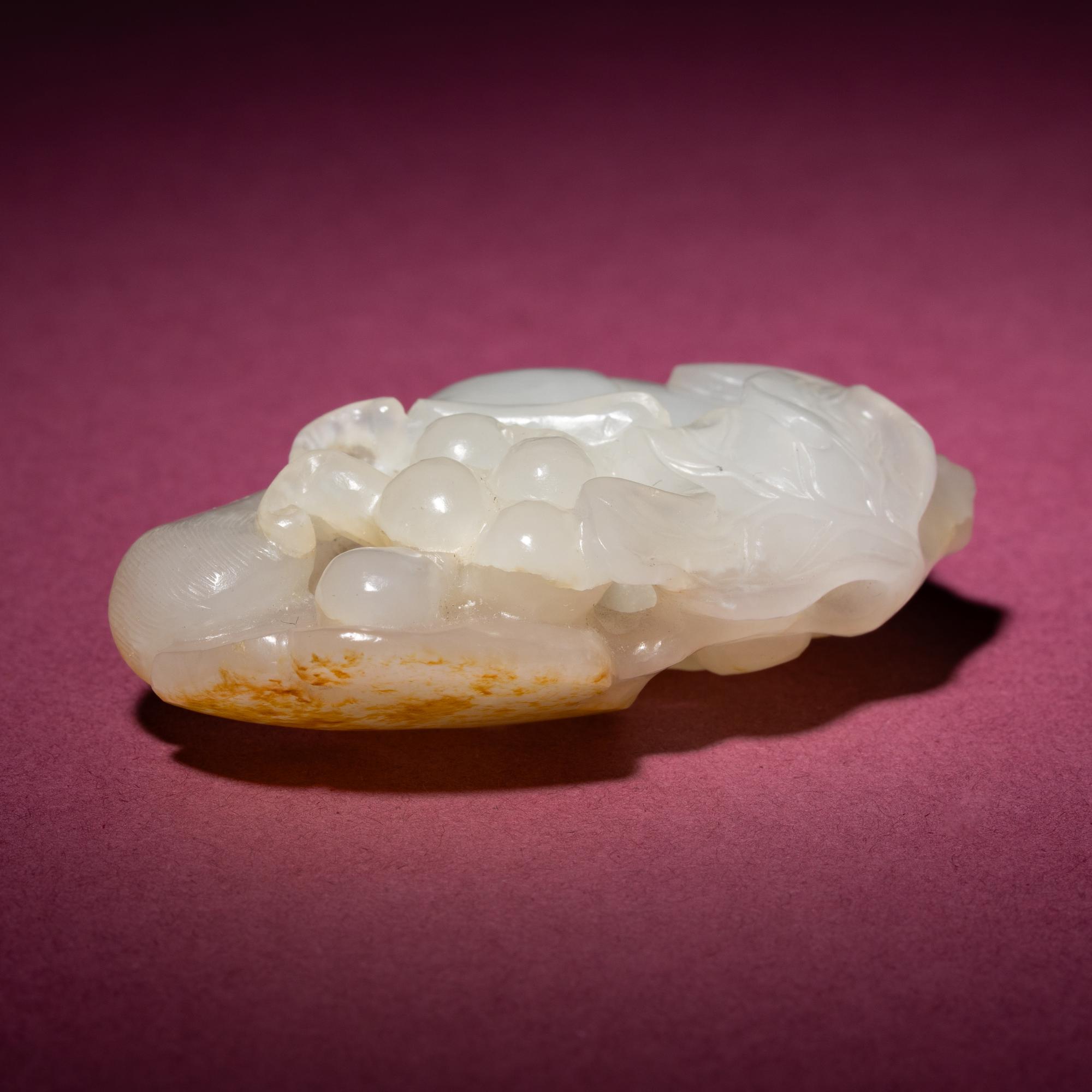 A Chinese Russet and White Jade 'Squirrel and Grape' Carving, 18th/19th Century — 清中期 白玉留皮松鼠葡萄