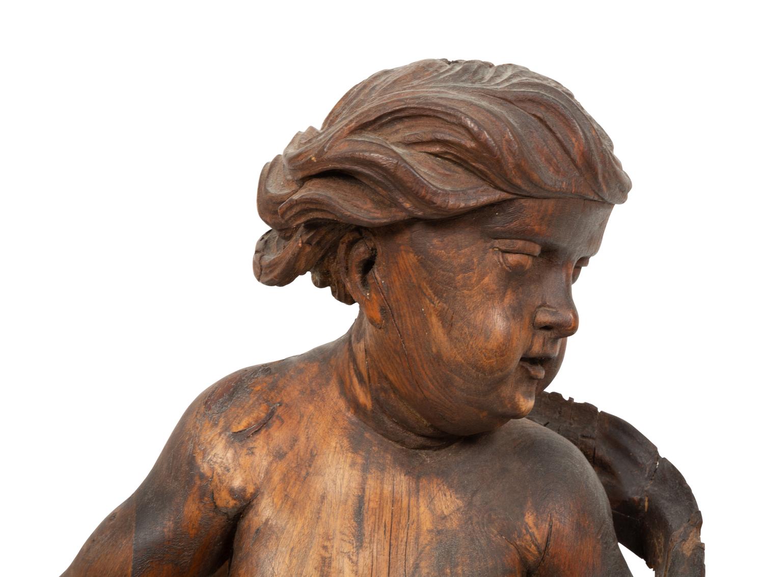 An Italian Carved Walnut Figure of Putto