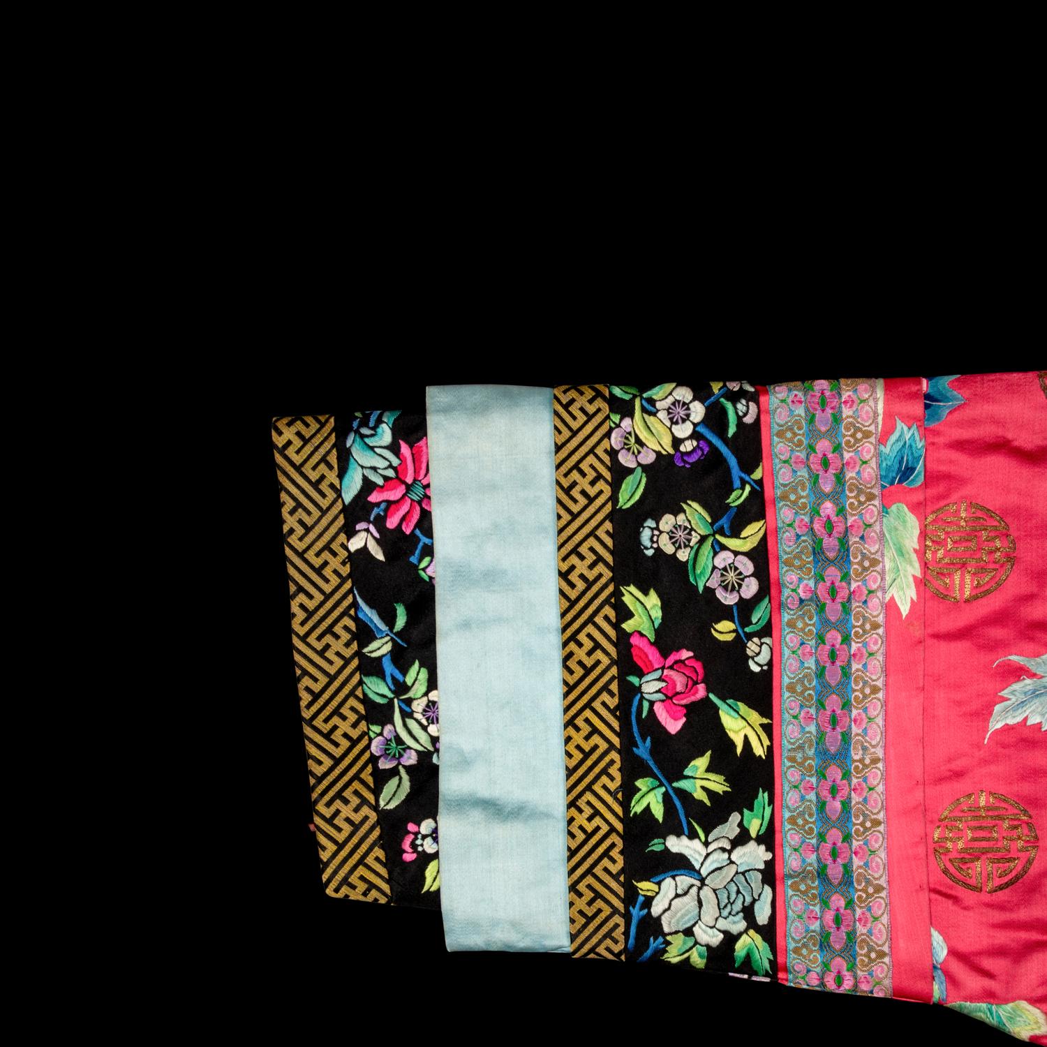 A Chinese Red Ground Embroidered Silk Manchu Lady's Informal Robe, Changyi, Late 19th Century 清晚期 桃紅緞綉牡丹團壽紋氅衣