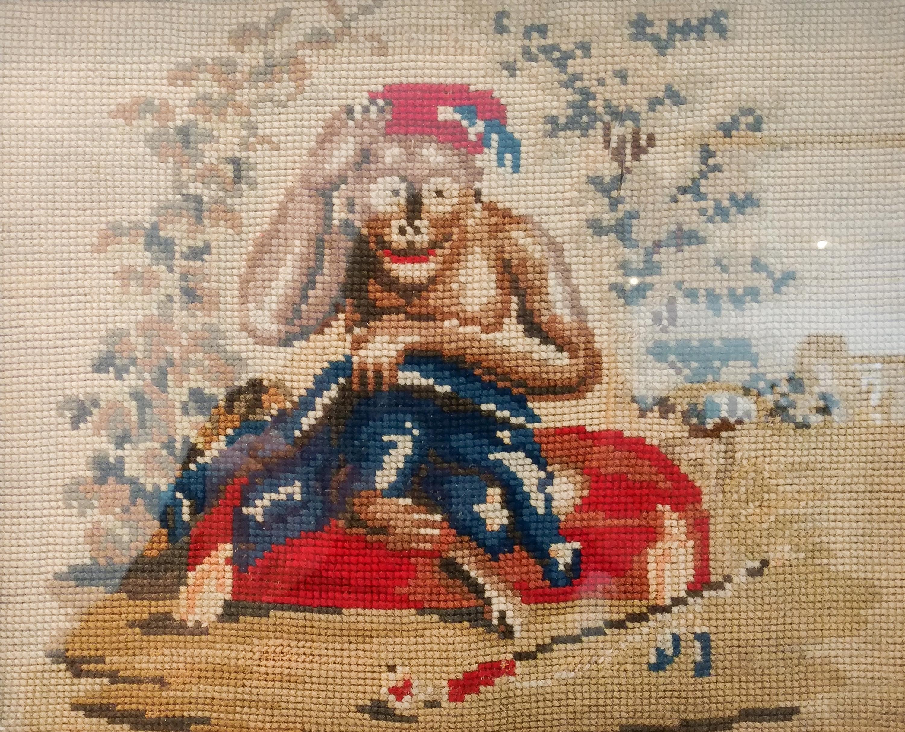 A Framed Needlepoint of a Monkey Height 9 x width 11 1/4 inches.