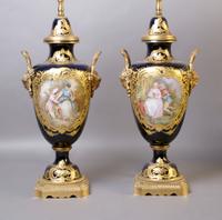 A Pair of Sevres Porcelain and Gilt Metal Mounted Covered Urns, Height 16 1/4 inches.