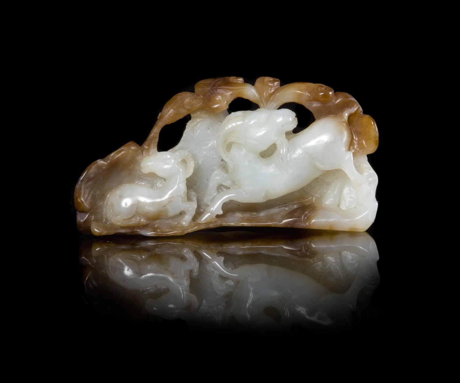 A Chinese Carved Russet and White Jade Figural Group of Double Rams Length 2 5/8 inches. — QING DYNASTY (1644-1912)