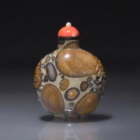A Chinese Carved Puddingstone Snuff Bottle, Qing Dynasty, Circa 1750-1820 — 1750-1820年 抱子石鋪首啣環耳鼻煙壺