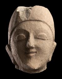 A Cypriot Limestone Head of a Man Wearing a Helmet