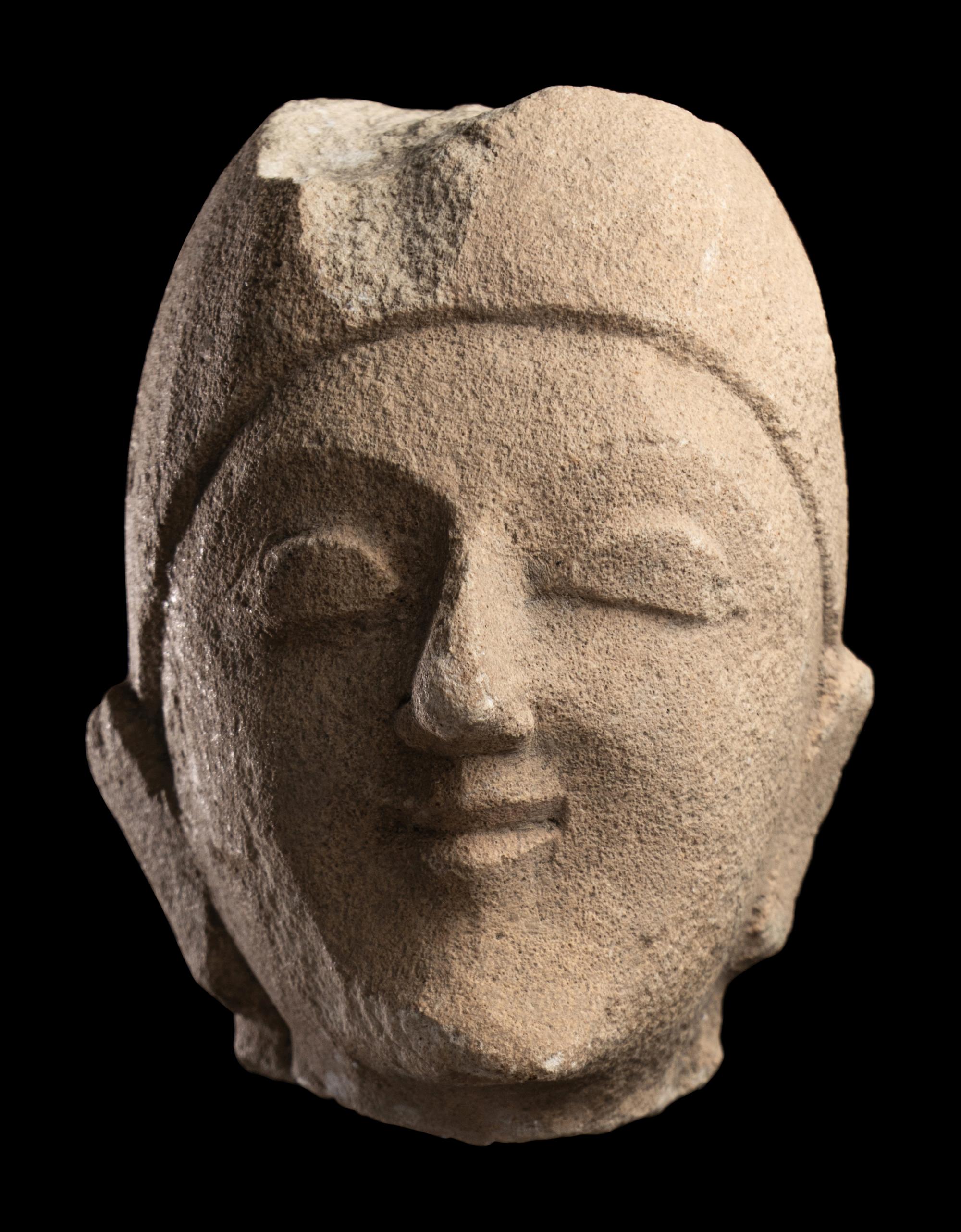 A Cypriot Limestone Head of a Man Wearing a Helmet
