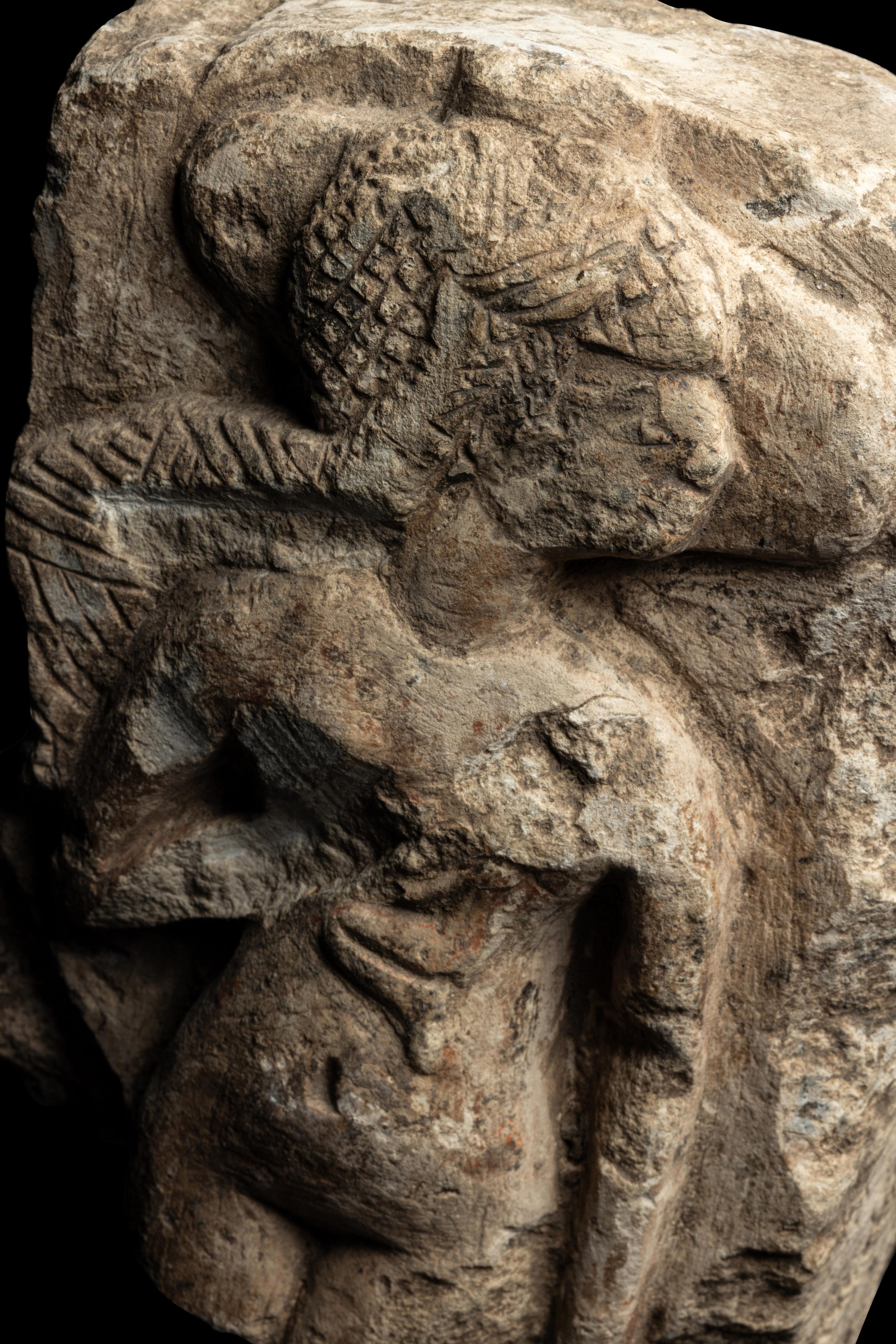 An Egyptian Limestone Fragment of a Mother Nursing her Child