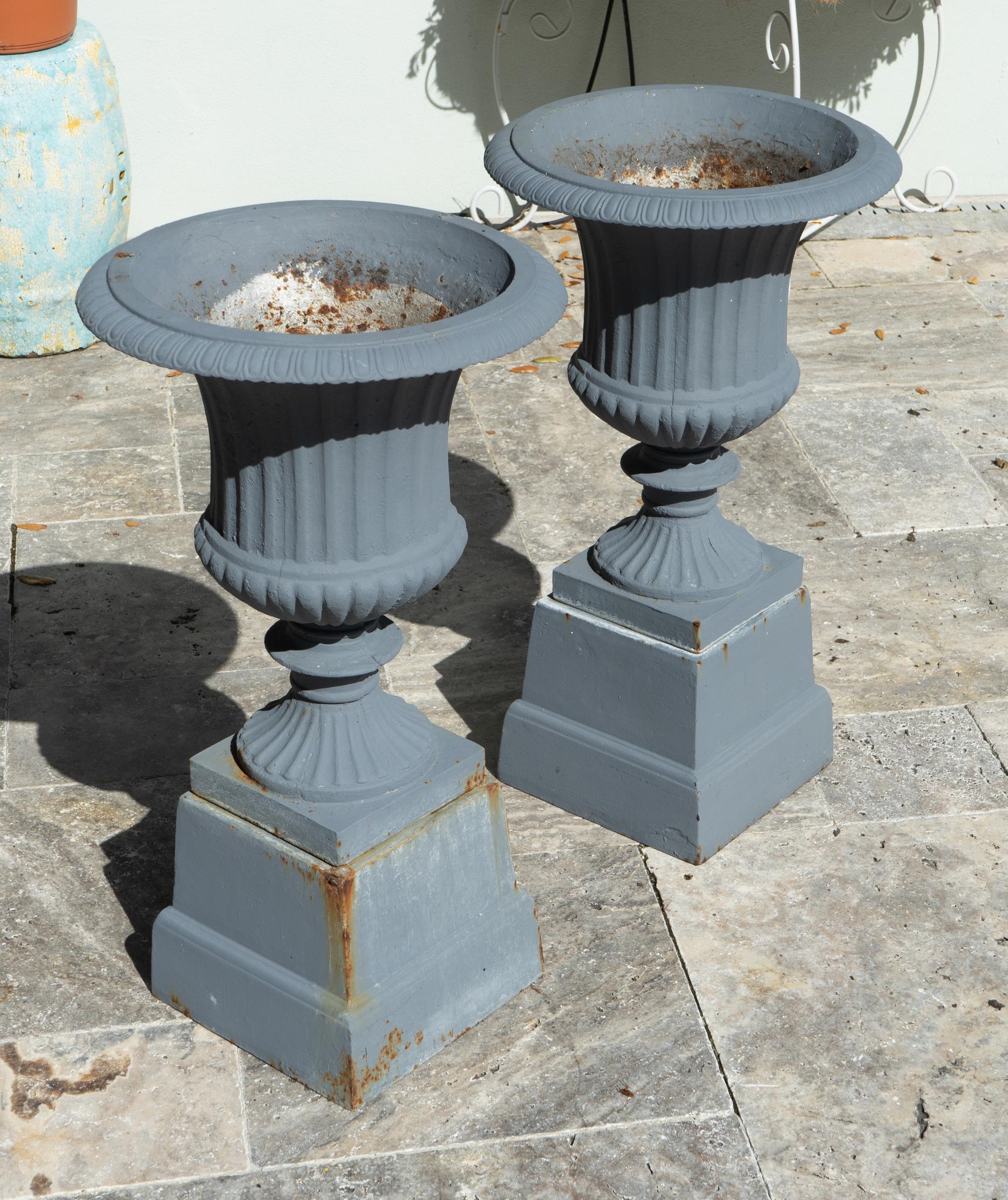 A Pair of Cast Iron Campana-form Jardinieres on Pedestals