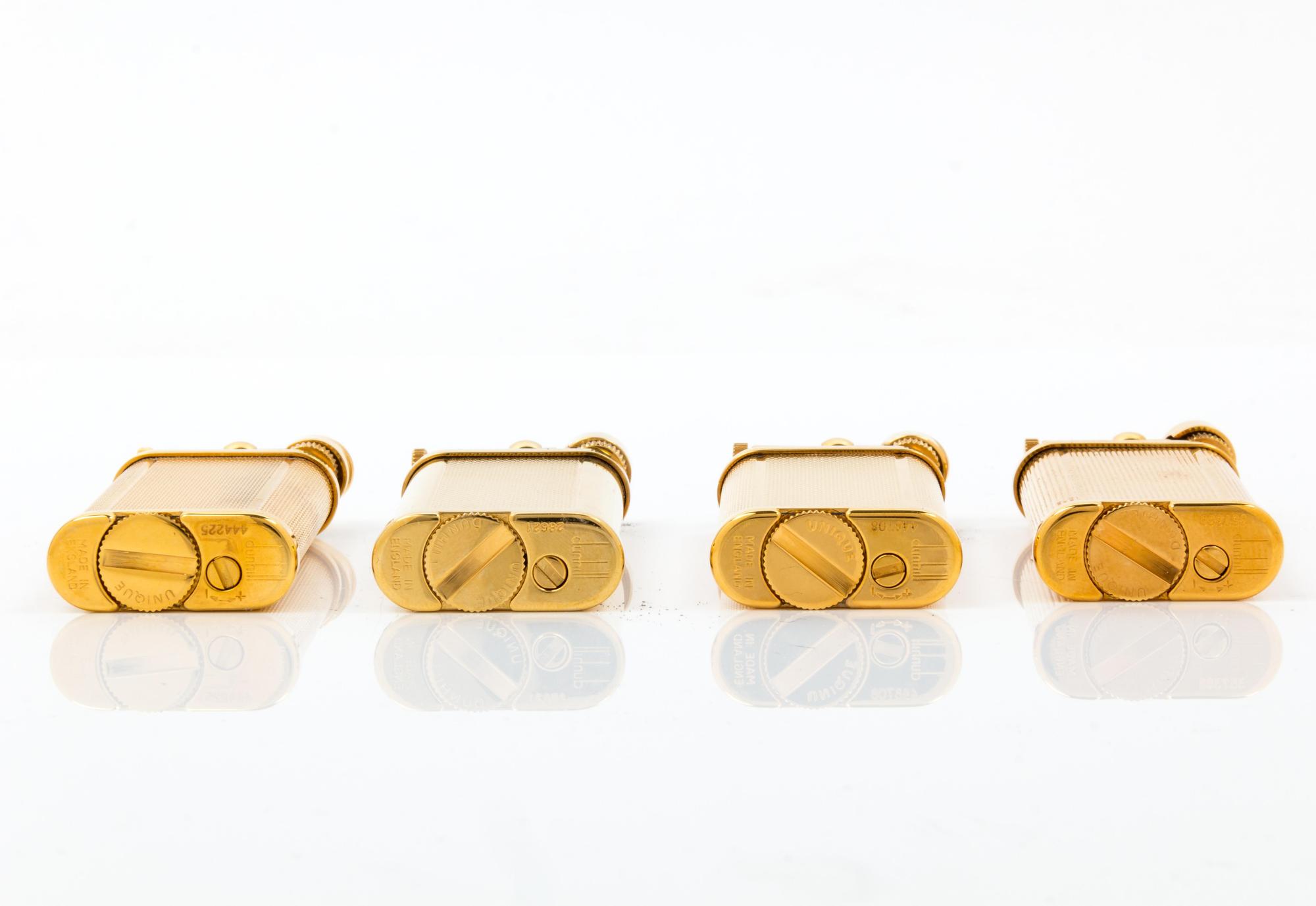 A Group of Four Gilt Metal Dunhill Lift-Arm Lighters