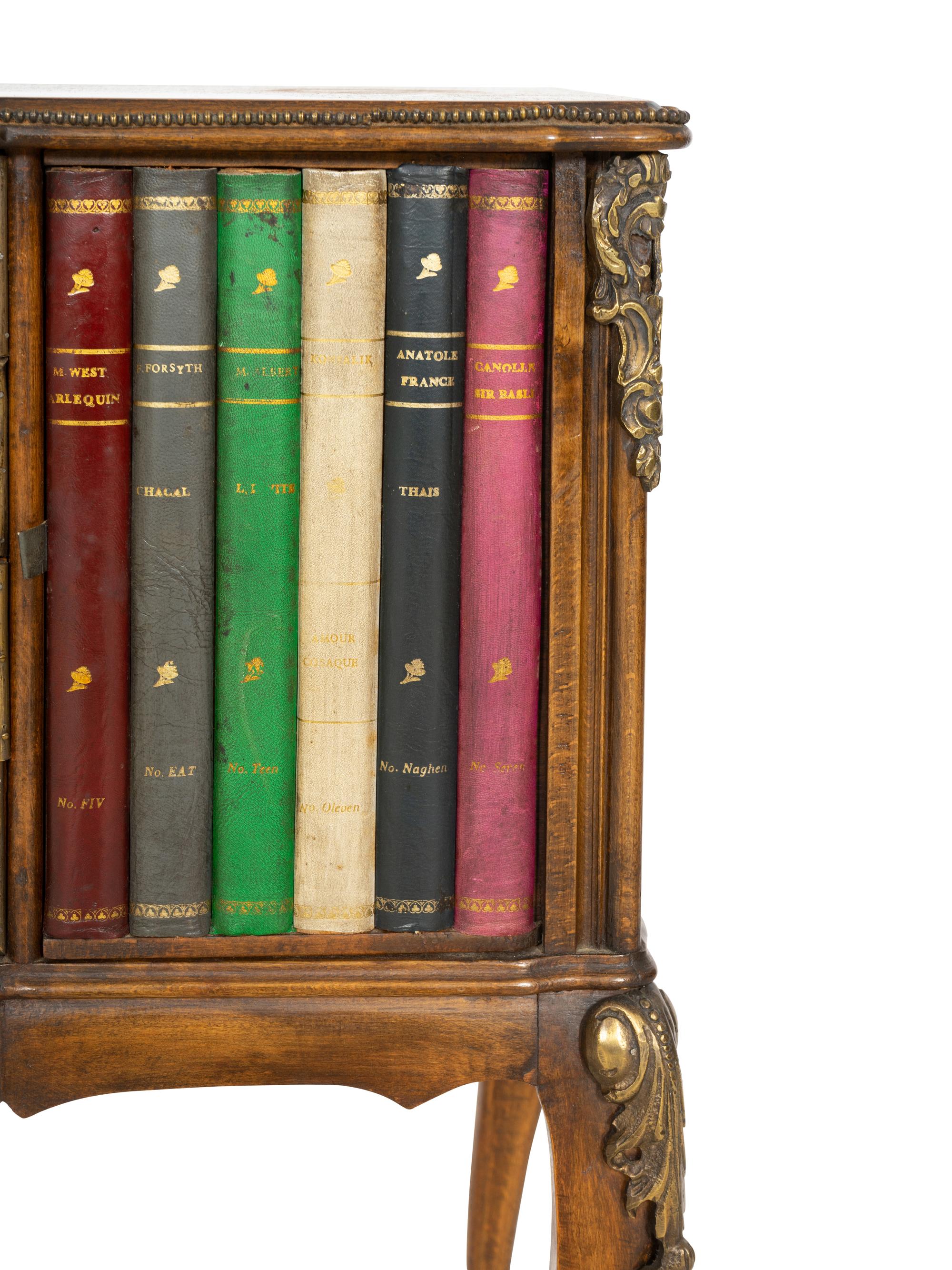 A Louis XV Style Walnut and Leather Faux Book-Front Cabinet