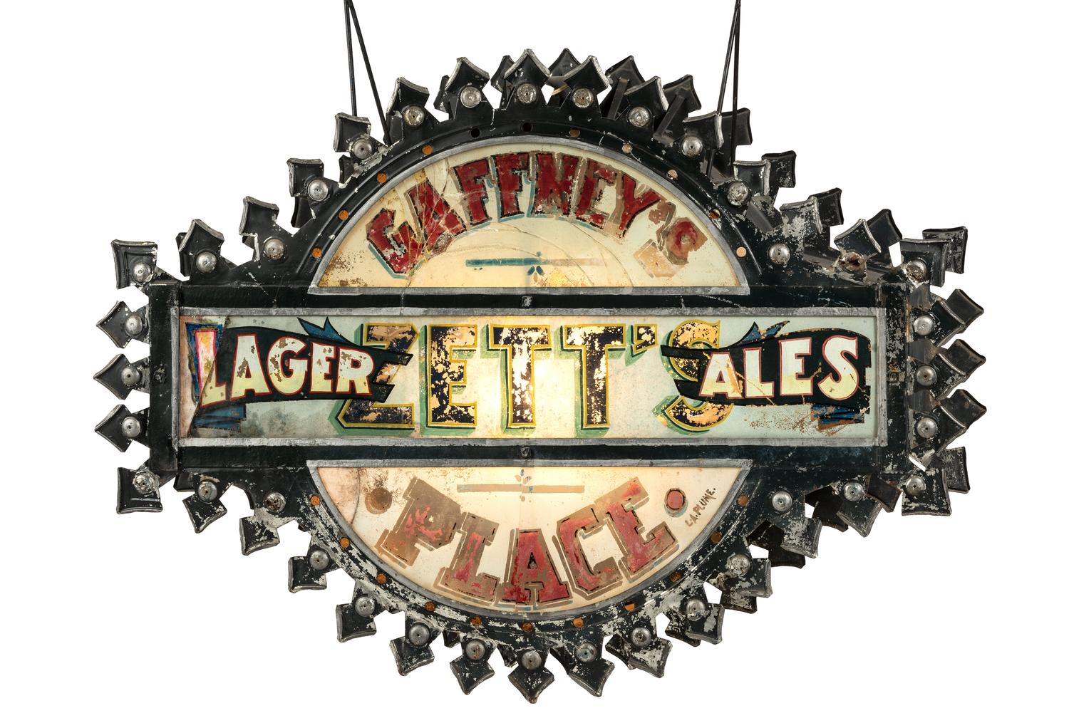 A Zett's Lager and Ales Reverse Painted Glass and Pressed Metal Double-Sided Lighted Bar Sign