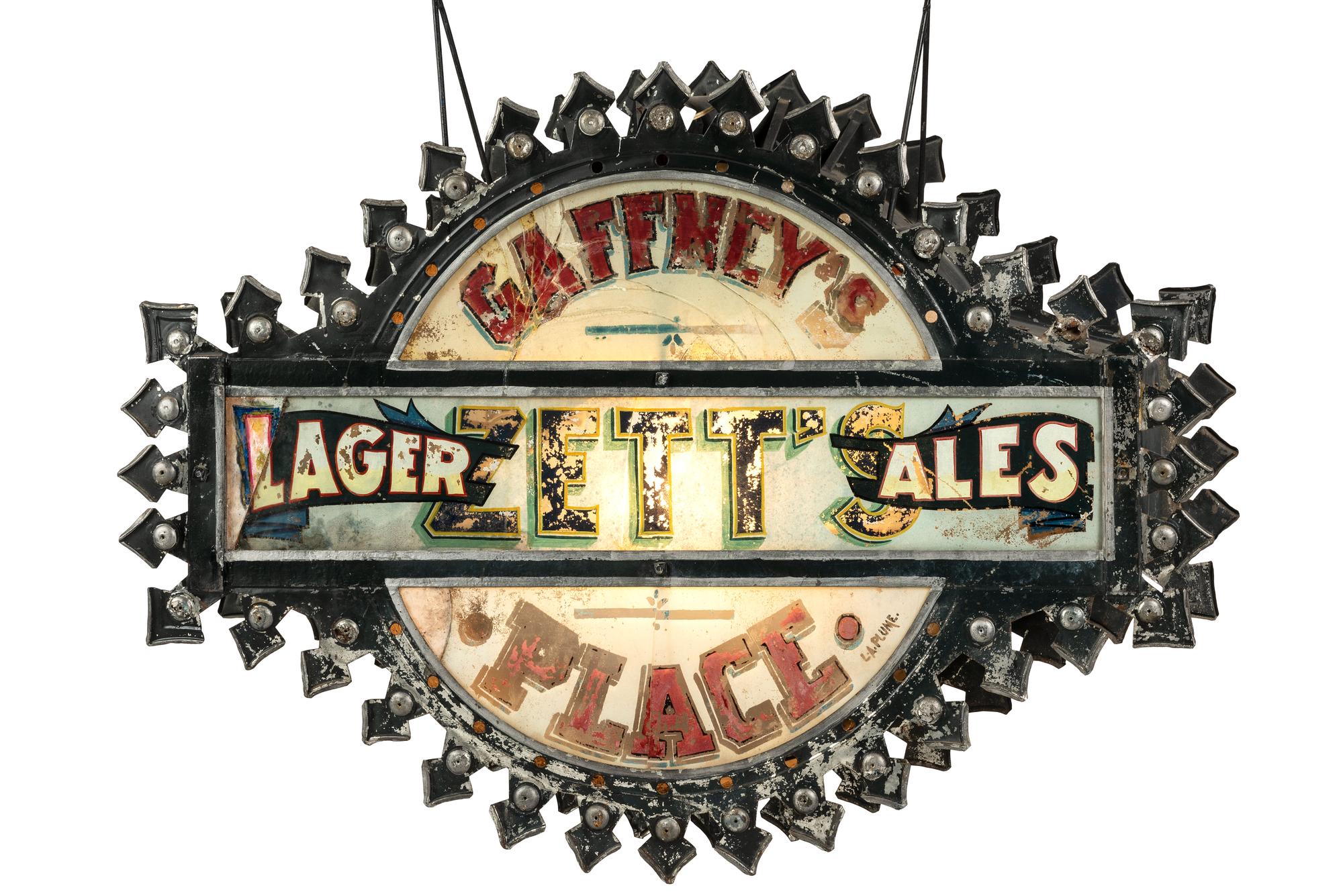 A Zett's Lager and Ales Reverse Painted Glass and Pressed Metal Double-Sided Lighted Bar Sign