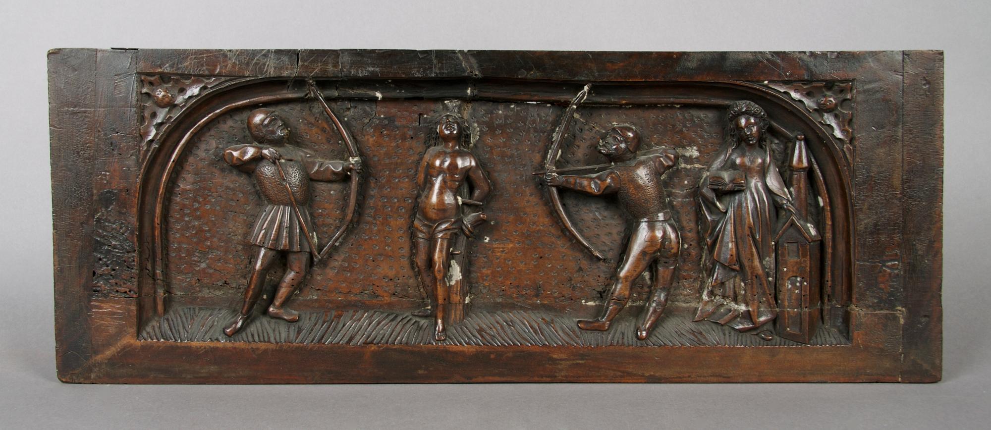 A Continental Carved Panel Depicting the Martyrdom of Saint Sebastian, Height 8 5/8 x width 23 inches.